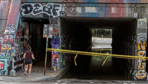 A runner enters the Krog Street tunnel side wallk from Dekalb Avenue on Thursday July 30th, 2020. The tunnel roadway was closed to traffic after it filled with water probably from overnight rainfall. PHIL SKINNER FOR THE ATANTA JOURNAL-CONSTITUTION
