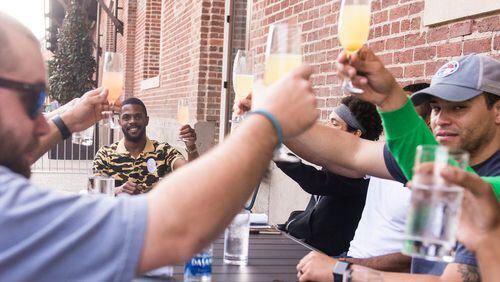 Averitt Scott and his bachelor's party raise a glass outside of Plant Riverside on Saturday. The group chose Savannah to celebrate Scott's upcoming nuptials.