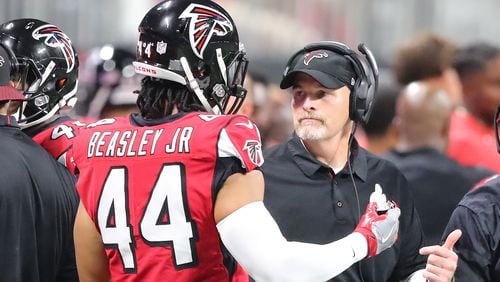 Falcons head coach Dan Quinn confers with Vic Beasley Jr. during the first half against the Green Bay Packers Sunday, Sept. 17, 2017, in Atlanta.