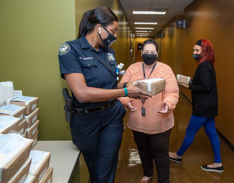Crystal Johnson (from left) hands lunches to MaryJo Bagnato and Wendy Gaspard, part of the 600 meals that Avalon Catering delivered to the Atlanta Public Safety headquarters in downtown Atlanta as part of Feed the Frontline. PHIL SKINNER FOR THE ATLANTA JOURNAL-CONSTITUTION.