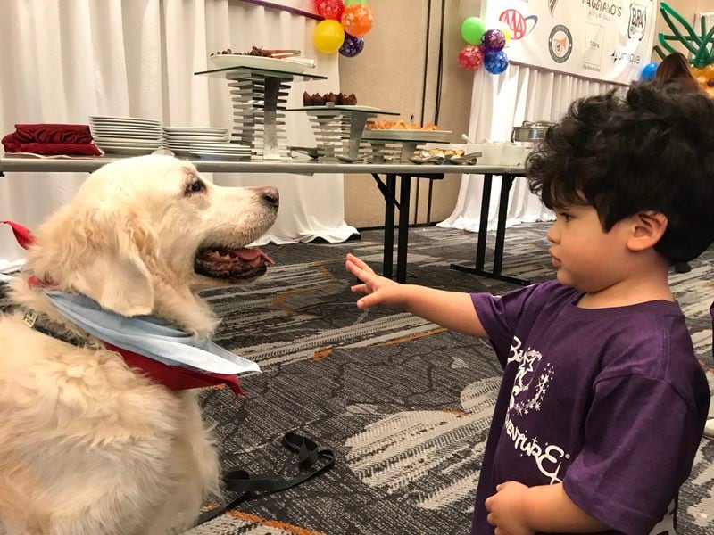  Max, the therapy dog, greets Mateo Escobar, whose brother Luis Escobar is one of Bert's Big Adventure kids who has a germ cell brain tumor. CREDIT: Rodney Ho/rho@ajc.com