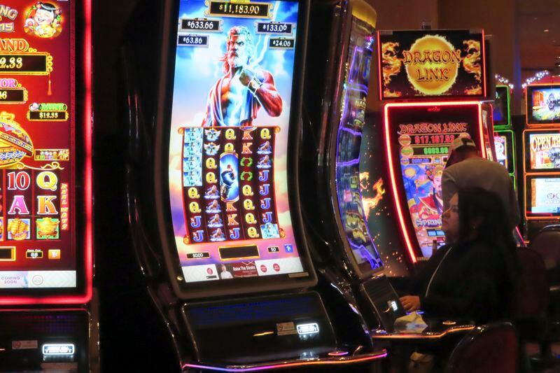 A gambler plays a slot machine at Harrah's casino in Atlantic City N.J. on Sept. 29, 2023. Figures released, Tuesday, April 16, 2024, show Atlantic City's casinos, their online partners and horse tracks that take sports bets won over $526 million in March, a month in which New Jersey's internet gambling market set yet another monthly record at $197 million. (AP Photo/Wayne Parry)