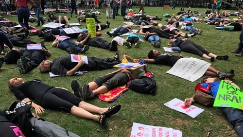 Protesters held a "die-in" at Woodruff Park as President Donald Trump headed Friday to Atlanta to speak to the National Rifle Association annual convention.