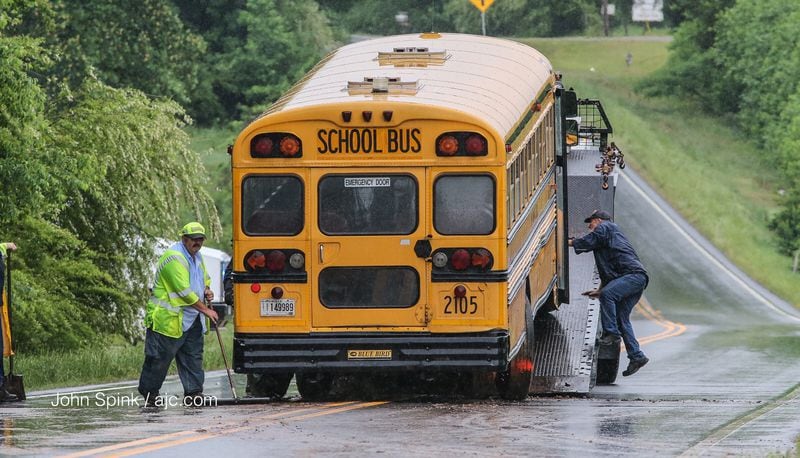 A Hall County school bus involved in a head-on collision Wednesday morning is loaded onto a wrecker. JOHN SPINK / JSPINK@AJC.COM  