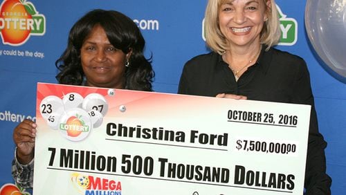 Christina Ford, 64 of Dallas, poses with her $7.5 million lottery check. She split a July jackpot with a winner in Virginia.