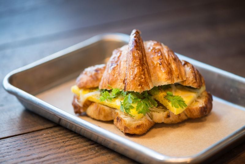 Egg and Cheese Croissant Sandwich with Comte cheese, herbs, and melted leeks. Photo credit- Mia Yakel.