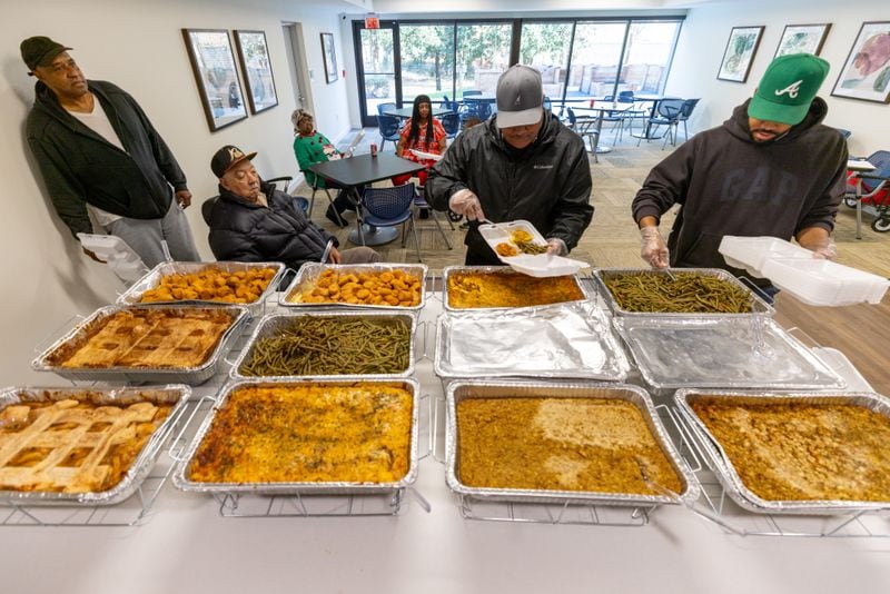Volunteers make up a Thanksgiving day meal for residents at the James Allen, Jr. Place apartments on Thursday, Nov. 23, 2023.  (Steve Schaefer/steve.schaefer@ajc.com)