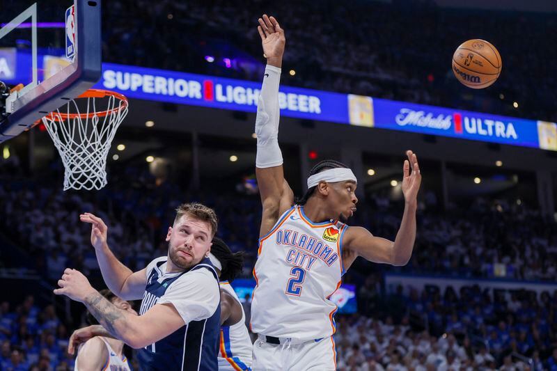 Oklahoma City Thunder guard Shai Gilgeous-Alexander (2) and Dallas Mavericks guard Luka Doncic look on while attempting a rebound during the first half of Game 1 of an NBA basketball second-round playoff series, Tuesday, May 7, 2024, in Oklahoma City. (AP Photo/Nate Billings)