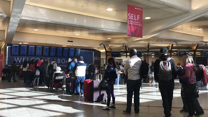 A line of passengers wait for Delta customer service at Hartsfield-Jackson on Saturday morning.
