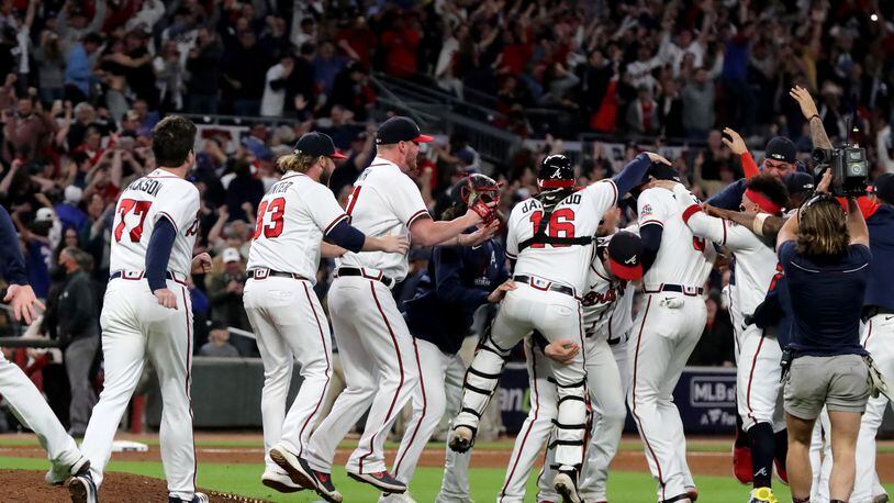 Braves players celebrate their 4-2 win against the Los Angeles Dodgers in Game 6 of the National League Championship Series at Truist Park on Saturday.  (Curtis Compton / curtis.compton@ajc.com)
