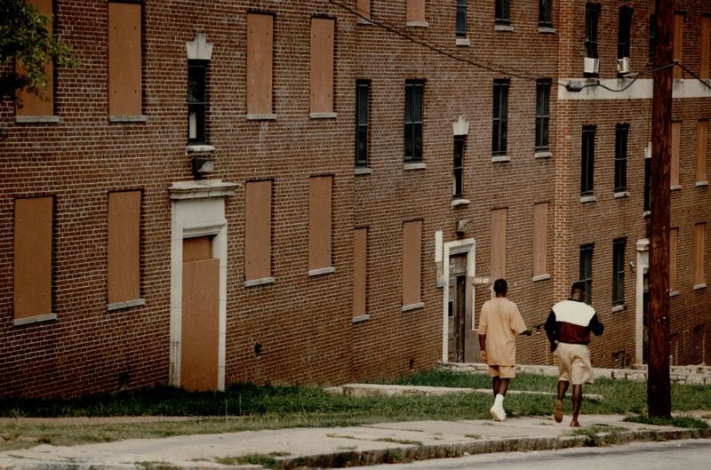 Two pedestrians walk by Techwood Homes, where some units are boarded up. Photographed on Aug. 17, 1993.
MANDATORY CREDIT: FRANK NIEMEIR / THE ATLANTA JOURNAL-CONSTITUTION