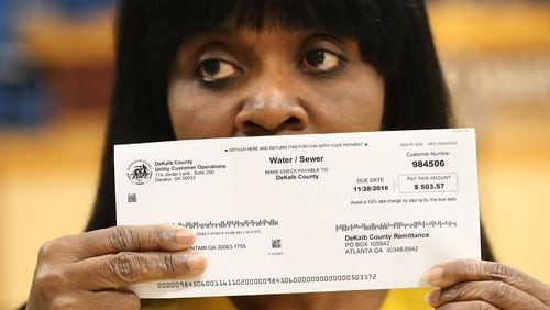 Viola Davis with her DeKalb County water bill for $503.57, demanding answers along with other local residents about excessively high water bills during a town hall meeting on Nov. 10, 2016, in Decatur. Curtis Compton/ccompton@ajc.com