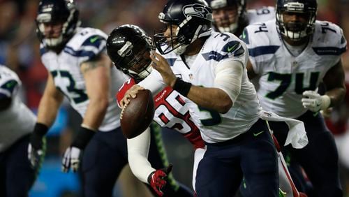 Atlanta Falcons defensive end Adrian Clayborn (99) pursues Seattle Seahawks quarterback Russell Wilson (3). Clayborn was lost on the third defensive snap in Saturday’s 36-20 playoff win over the Seahawks.