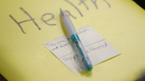 The health notebook of one of the students, with a sticky note with vaping facts written on it. Les Meenan, the health teacher at Webb Bridge Middle School, has had to modify his unit on alcohol and tobacco to increase the focus on vaping. BOB ANDRES / ROBERT.ANDRES@AJC.COM