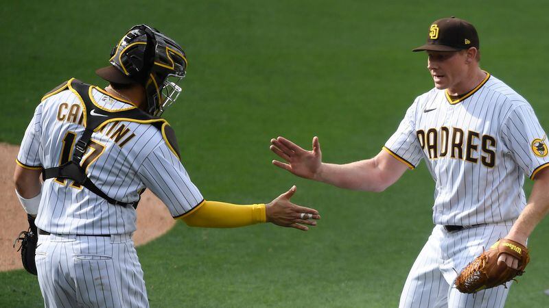 San Diego Padres relief pitcher Mark Melancon (right) is congratulated by catcher Victor Caratini after they defeated the Arizona Diamondbacks on opening day, Thursday, April 1, 2021, in San Diego. (Denis Poroy/AP)