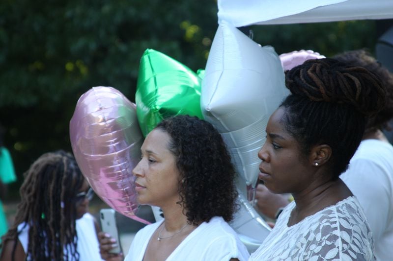 Aja Mann and Khaalisha Ajala, bathed in pink and green ballons -- the colors of the sorority -- at Maleka Jackson’s vigil in Atlanta.