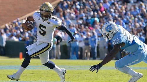 Georgia Tech’s Justin Thomas rolls out under pressure from North Carolina’s Cayson Collins during last week’s game at Kenan Stadium in Chapel Hill, N.C. (Photo by Grant Halverson/Getty Images)