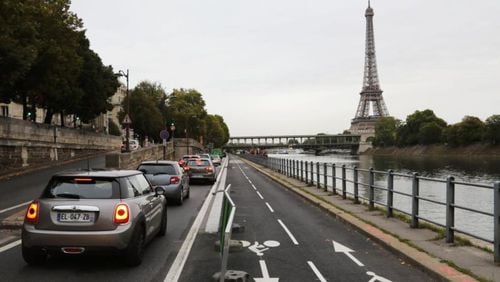 A picture taken on September 4, 2017 shows the newly created bicycle track next to cars stuck in a traffic jam along the Seine River near the Bir Hakeim Bridge in Paris. 
In 2015, the city launched the 'Plan Vélo', a project worth 150 million euros, with the aim of doubling the number of kilometres of cycling tracks (from 700 to 1,400 km) among others.  (LUDOVIC MARIN/AFP/Getty Images)