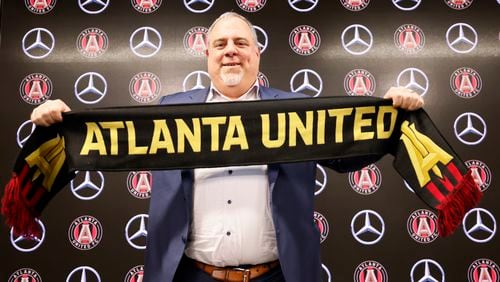 Garth Lagerwey poses with an Atlanta United scarf after being introduced Tuesday in Atlanta as the club's CEO and president. (Miguel Martinez / miguel.martinezjimenez@ajc.com)