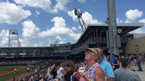 Mary Herrington of Memphis, Tenn. takes in the start of the total solar eclipse in Nashville at First Tennessee Park.