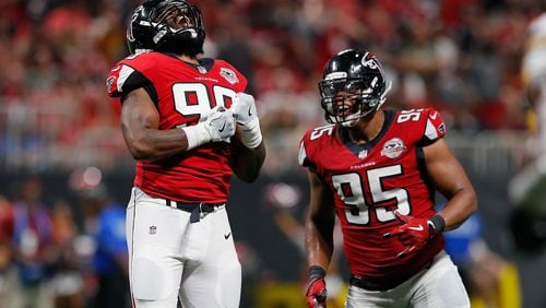 Adrian Clayborn #99 celebrates with Jack Crawford of the Falcons after sacking Aaron Rodgers of the Packers (not pictured) during the second half at Mercedes-Benz Stadium on September 17 in Atlanta.