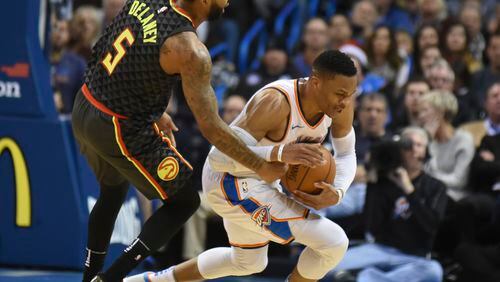 Hawks' Malcolm Delaney, left, tries to get the ball away from Oklahoma City's Russell Westbrook, right, in the third quarter of an NBA basketball game in Oklahoma City, Friday, Dec. 22, 2017. (AP Photo/Kyle Phillips)