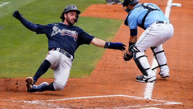 Braves shortstop Dansby Swanson (7) scores ahead of the throw to Tampa Bay Rays catcher Mike Zunino (10) on a two-run base hit by Jake Lamb in the second inning Sunday, March 21, 2021, in Port Charlotte, Fla. (John Bazemore/AP)