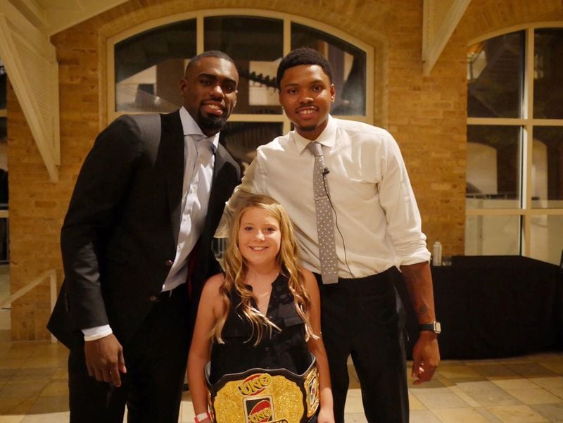 Eleven-year-old Gracie Weeks (center) won the first Kent Bazemore (right) Uno Tournament night at the Fernbank Museum.  (Now former) Hawks teammate Tim Hardaway Jr. is also pictured. (Photo provided)