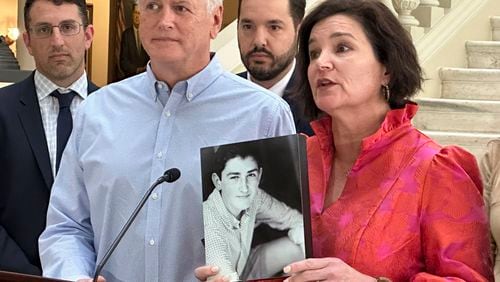 Dana Pope, with her husband John by her side, holds a photo of her son, Ethan, as she speaks at a news conference at the Georgia Capitol on May 2, 2024, after Gov. Brian Kemp signed a bill to regulate kratom. Extracted from the leaves of a tropical tree native to Southeast Asia, kratom is used to make capsules, powders and liquids. It's often sold in gas stations or smoke shops, marketed as an aid for pain, anxiety and drug dependence.The Popes say their son died after using kratom and that they hope the newly signed legislation will prevent other families from having to go through what they did. (AP Photo/Kate Brumback)