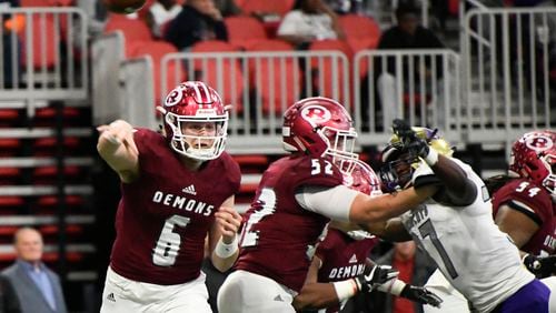 Warner Robins QB Dylan Fromm (6) passes as Bainbridge LB Eric Sanders jr., right, defends during their class 5A high school championship football game, Tuesday, Dec., 11, 2018, at Mercedes-Benz Stadium, in Atlanta.