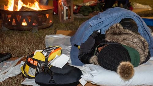 An Atlanta business executive tries to keep warm during the Covenant House Georgia Executive Sleepout last week. More than 160 sleepers braved the 30-degree temperatures to raise $897,000, which will go toward programs, services and housing to support Atlanta’s homeless youth. CONTRIBUTED BY TRACI KRUGER / TRALYNNPHOTOGRAPHY