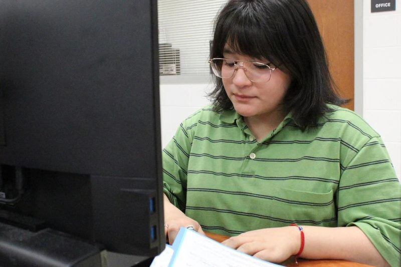 Betania Pena, a senior at Osborne High School, reviews tax documents as she completes a tax return as part of the school’s tax preparation program. (Photo Courtesy of Joe Adgie)