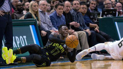 Atlanta Hawks guard Dennis Schroder, left, dives for a loose ball against Milwaukee Bucks guard Eric Bledsoe, right, during the second half of an NBA basketball game Tuesday, Feb. 13, 2018, in Milwaukee. (AP Photo/Darren Hauck)