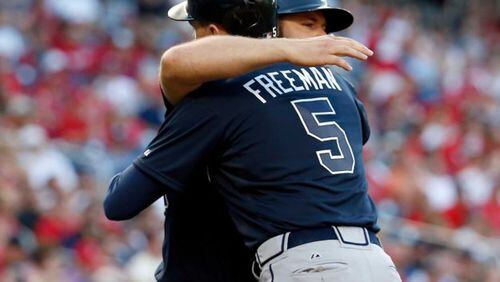 Freddie Freeman hugs Evan Gattis after Freeman's 1st-inning homer off the Nats' Stephen Strasburg on Friday. Gattis has been on fire for weeks, and now Freeman is heating up again.