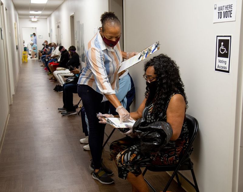 Xavier Benjamin fills out paperwork before voting at the South Fulton Service Center early on Friday morning, May 22, 2020. Benjamin said she arrived at the center at 6:20 am to secure her first place in line. STEVE SCHAEFER FOR THE ATLANTA JOURNAL-CONSTITUTION