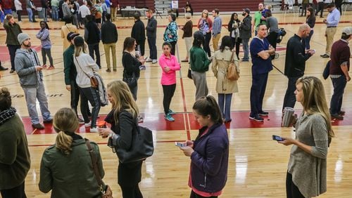 A triple line of voters at the Grady High School gymnasium in Atlanta as they wait to cast their votes on Tuesday morning, November 8 2016. JOHN SPINK / AJC
