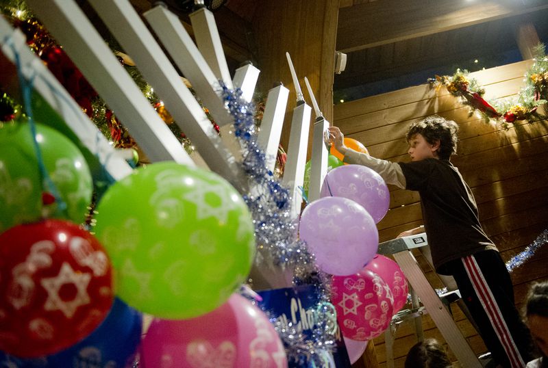 A boy helps decorate a 10-foot menorah during a Hanukkah celebration in Norcross in 2012. Jonathan Phillips / Special / AJC File