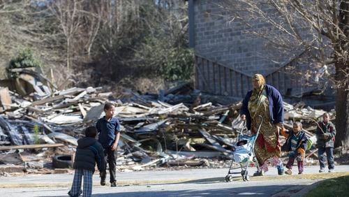Olympia Thompson walks her five boys past the remains of one of the burned out units in the Brannon Hill complex in this file photo from February 2016.