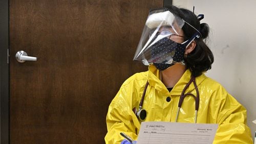 Dr. Jina Yoon Kim wearing hand made protection suits prepares to administer a flu test to a patient at Pleasant Hill Family Medicine in Duluth on Friday, April 3, 2020. HYOSUB SHIN / HYOSUB.SHIN@AJC.COM