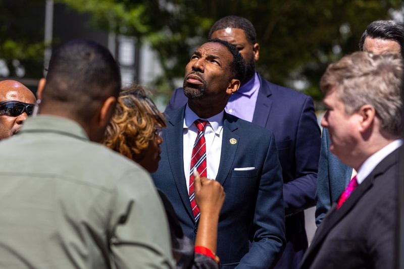 Mayor Andre Dickens, center, looks toward the Northside Hospital Midtown medical office building where five people were shot on Wednesday, May 3, 2023. One person died. (Arvin Temkar/The Atlanta Journal-Constitution)