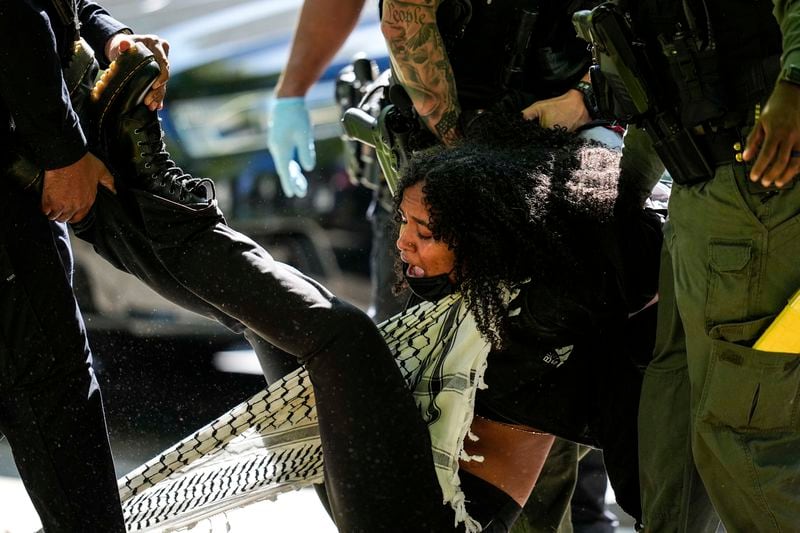 Authoritioes detain a protester on the campus of Emory University during an Israel Palestinian demonstration, Thursday, April 25, 2024, in Atlanta. (AP Photo/Mike Stewart)