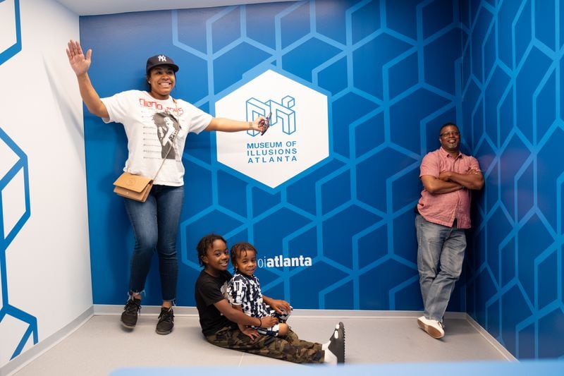 The Curry family, Devoria, from left, Aiden, Kaceson and Raymond, play in the Ames room at the Museum of Illusions Atlanta in Atlantic Station on Sunday, May 21, 2023.  (Ben Gray / Ben@BenGray.com)