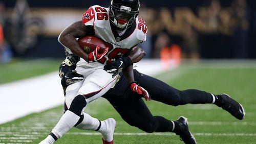 Tevin Coleman #26 of the Atlanta Falcons runs with the ball as Demario Davis #56 of the New Orleans Saints defends during the first half at the Mercedes-Benz Superdome on November 22, 2018 in New Orleans, Louisiana. (Photo by Sean Gardner/Getty Images)