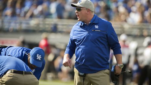 Kentucky head coach Mark Stoops, center, argues with referee Reggie Smith, left, during the first half of the TaxSlayer Bowl NCAA college football game against Georgia Tech, Saturday, Dec. 31, 2016, in Jacksonville, Fla. (AP Photo/Stephen B. Morton)