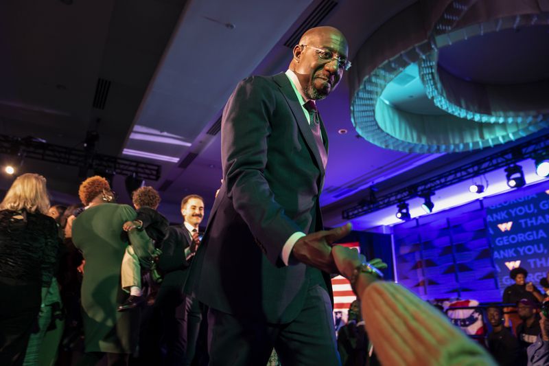 Sen. Raphael Warnock (D-Ga.) shakes hands with supporters after winning his reelection bid for Senate, in Atlanta on Tuesday, Dec. 6, 2022. (Nicole Craine/The New York Times)
