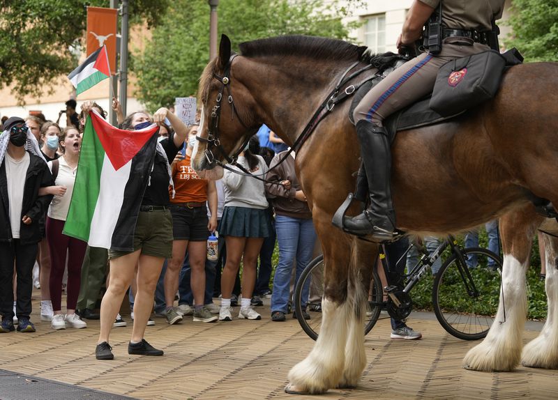 Cally, a former UT student, faces off with a mounted state trooper at a pro-Palestinian protest at the University of Texas, Wednesday, April 24, 2024, in Austin. (Austin American-Statesman via AP)