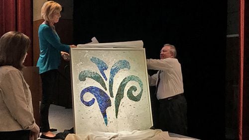Artist Sue Carlson and City Councilman John Paulson unveil a mosaic depicting the Sandy Springs city logo, a gift to the city. CITY OF SANDY SPRINGS