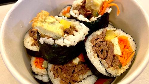 Kimbap, sometimes spelled gimbap, is a Korean-style sushi roll made from cooked rice and other ingredients rolled in dried seaweed and served in bite-size pieces. Let’s Bap offers bulgogi kimbap and a vegetarian version. Ligaya Figueras/ligaya.figueras@ajc.com