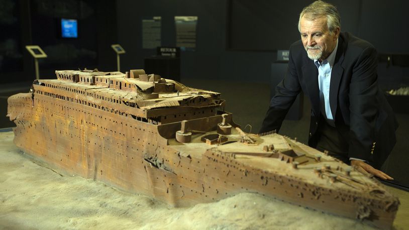 Paul-Henri Nargeolet, director of a deep ocean research project dedicated to the Titanic, poses next to a miniature version of the sunken ship inside a new exhibition, at 'Paris Expo', on May 31, 2013, in Paris. (JOEL SAGET/AFP via Getty Images)