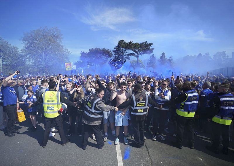 Fans are held back by security ahead of the English Championship soccer match between Ipswich Town and Huddersfield Town at Portman Road, in Ipswich, Saturday, May 4, 2024. (Zac Goodwin/PA via AP)